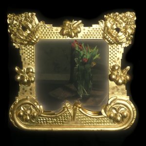 Frame based on a floral design of Camsis Grandiflora. Carved in lime and water gilded. It has a special glass which, I think, was originally used in discotheques